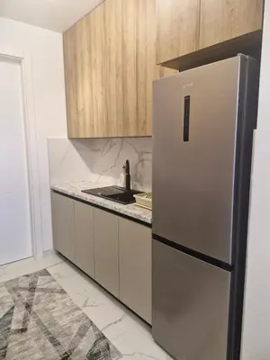 a kitchen with a stainless steel refrigerator and wooden cabinets at Stay & Enjoy Apartment in Banja Luka