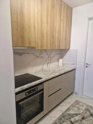 a kitchen with a stove and wooden cabinets at Stay & Enjoy Apartment in Banja Luka
