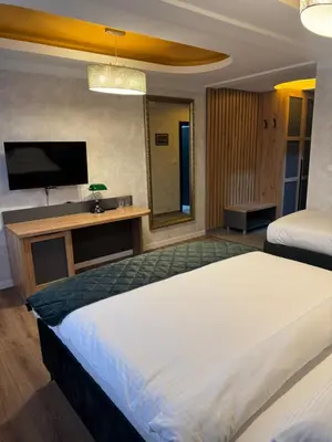 a bedroom with two beds and a flat screen tv at Pansion Afitos in Laktaši