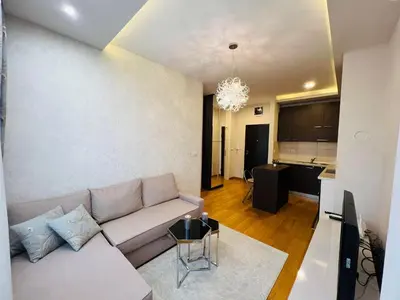 a living room with a couch and a kitchen at Apartman Tara 23 in Banja Luka