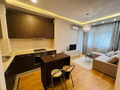 a kitchen and living room with a table and chairs at Apartman Tara 23 in Banja Luka