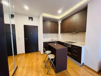 a kitchen with brown cabinets and a black counter top at Apartman Tara 23 in Banja Luka