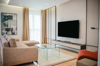 a living room with a couch and a tv on a wall at Stars Hotel in Jelah