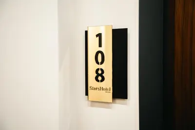 a black and white clock on a white door at Stars Hotel in Jelah