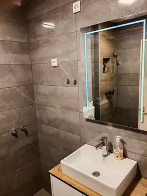 a bathroom with a sink and a shower with a mirror at Vrbas in Banja Luka