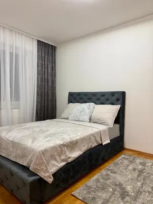 a bedroom with a bed with a black headboard at Apartmani Alexa in Banja Luka