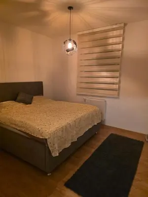 a bedroom with a bed and a window with a light at Stan na dan -Lukavac in Lukavac