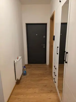 a hallway with a black door and a wooden floor at Stan na dan -Lukavac in Lukavac