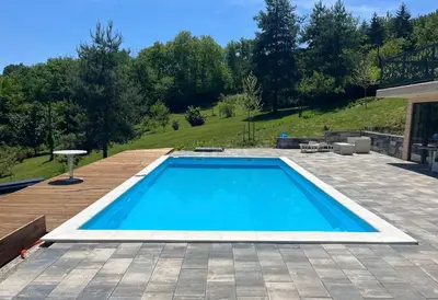a large swimming pool in a yard with a patio at Šumska Duša in Banja Luka