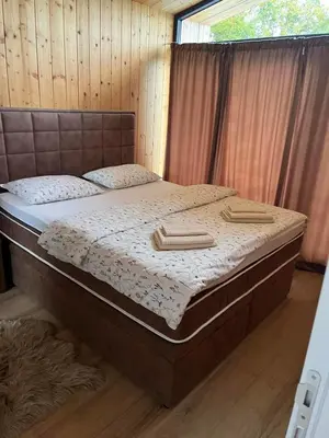 a large bed in a room with a wooden floor at Šumska Duša in Banja Luka