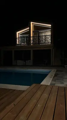 a building with a balcony and a swimming pool at night at Šumska Duša in Banja Luka