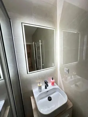 a white bathroom with a sink and a mirror at Apartman Gak 2 in Banja Luka