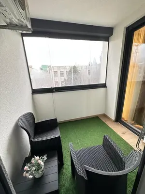 a room with two chairs and a table and a window at Apartman Gak 2 in Banja Luka