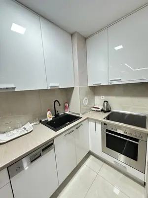a kitchen with white cabinets and a sink at Apartman Gak 2 in Banja Luka