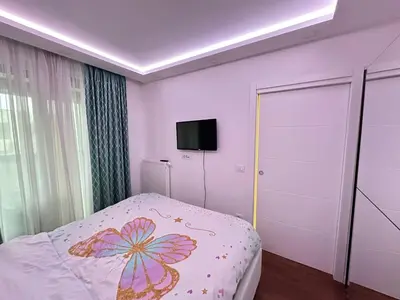 a bedroom with a bed and a tv on the wall at Apartman Gak 2 in Banja Luka
