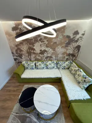 a living room with a green couch and a table at Apartman Hendek Tuzla in Tuzla