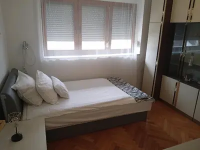 a small bedroom with a bed with a window at Retro-Apartman in Prijedor