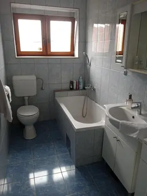 a bathroom with a tub and a toilet and a sink at Retro-Apartman in Prijedor