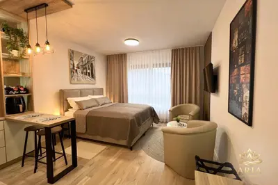a hotel room with a bed and a table at ARIA Luxury Apartment, Tuzla in Tuzla
