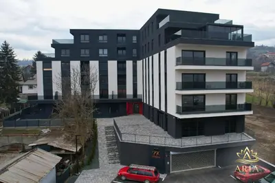 a building with a red car parked in front of it at ARIA Luxury Apartment, Tuzla in Tuzla