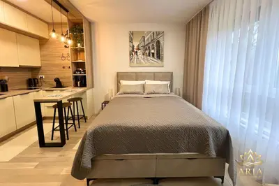 a small bedroom with a bed and a kitchen at ARIA Luxury Apartment, Tuzla in Tuzla