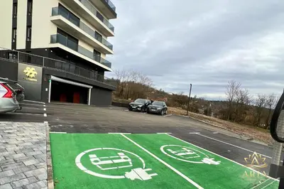 a parking lot with cars parked in front of a building at ARIA Luxury Apartment, Tuzla in Tuzla