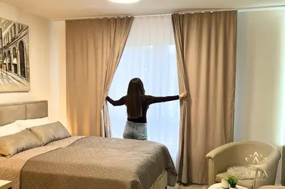 a woman looking out the window of a hotel room at ARIA Luxury Apartment, Tuzla in Tuzla