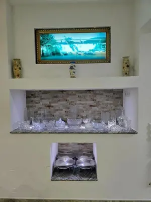 a shelf with glasses and bowls on a fireplace at Teo FAMILY APARTMENT TUZLA in Tuzla