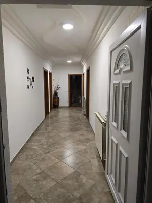 a hallway with white walls and a tile floor at Teo FAMILY APARTMENT TUZLA in Tuzla