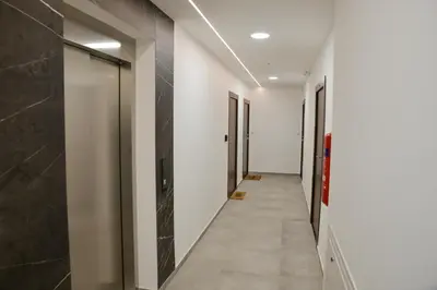 a corridor with white walls and a hallway with doors at New City Nest - Tuzla Center in Tuzla