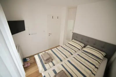 a small bedroom with two beds with striped pillows at New City Nest - Tuzla Center in Tuzla