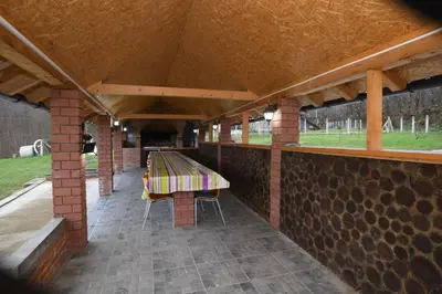 a pavilion with a table and chairs on a patio at Vikendica Ivanović in Banja Luka