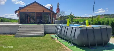a playground in front of a house with a pool at Kuća za odmor River Nest
