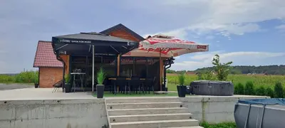 a restaurant with umbrellas and a table and chairs at Kuća za odmor River Nest