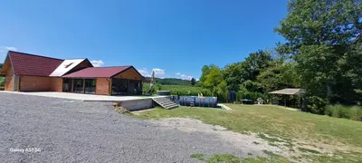 a house with a gravel driveway next to a building at Kuća za odmor River Nest