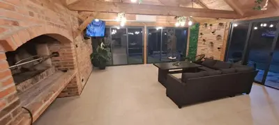 a living room with a couch and a brick fireplace at Kuća za odmor River Nest
