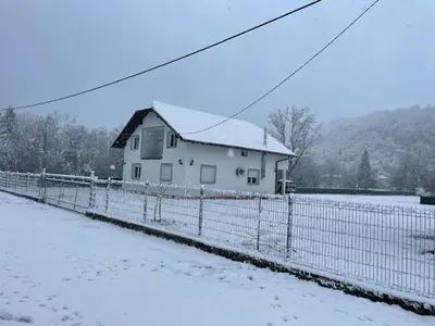 a white house with a fence in the snow at Domaćinstvo Kondić