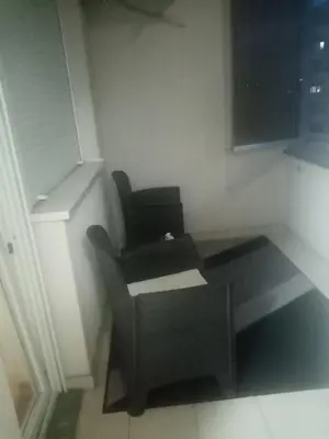 a black chair and a table in a room at Apartman s garazom in Banja Luka