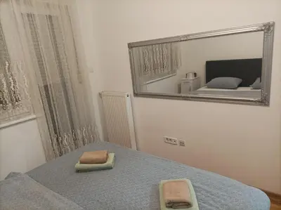 a bedroom with a mirror and a bed with two towels at Apartman s garazom in Banja Luka
