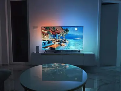 a living room with a tv and a glass table at Splendida in Bosanska Gradiška