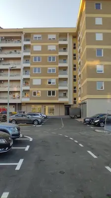 a parking lot in front of a large building at Apartman Lena 51 BL in Železnička Stanica Incel