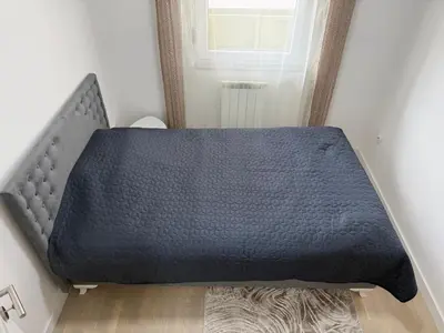 a bed in the corner of a room at Urban Home Stupine in Ši Selo