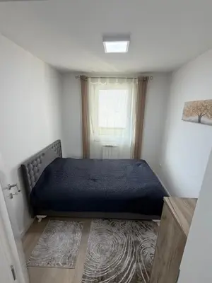 a bedroom with a bed in a room with a window at Urban Home Stupine in Ši Selo