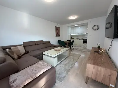 a living room with a brown couch and a table at Urban Home Stupine in Ši Selo