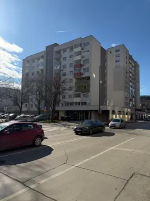 a parking lot with cars parked in front of a building at Urban Home Stupine in Ši Selo
