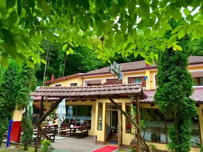 a building with a table and chairs in front of it at Motel Stovrela in Cazin