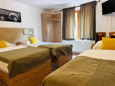 a hotel room with two beds and a television at Motel Stovrela in Cazin
