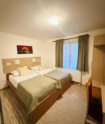 a bedroom with two beds and a window at Motel Stovrela in Cazin