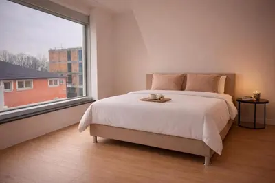 a bedroom with a large bed and a large window at BERLINA RESIDENCE Luxury Apartment in Bihać