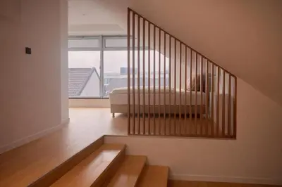 a room with a staircase with a couch and a window at BERLINA RESIDENCE Luxury Apartment in Bihać